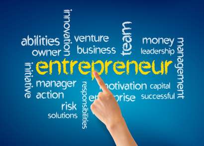 Woman's hand pointing at the word Entrepreneur