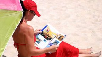 Woman reads magazine on a beach