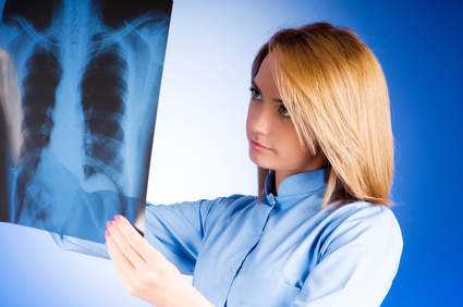 Female doctor carefully examining  x-ray of lungs of patient